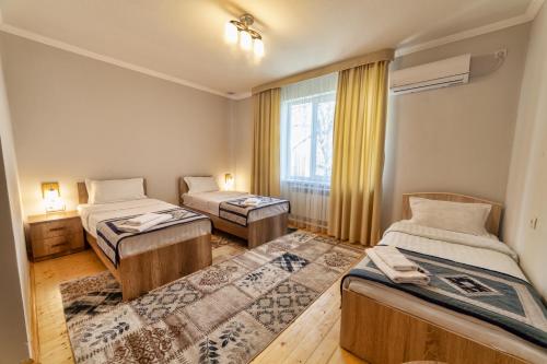 オシにあるTES Hotelのベッドが2つと窓のある部屋