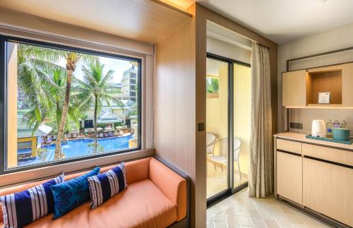 a living room with a couch and a large window at Holiday Inn Resort Phuket, an IHG Hotel in Patong Beach