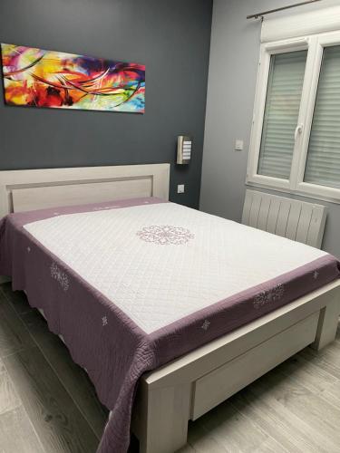 un letto in una camera da letto con un materasso viola di La maison des biquettes a Romorantin