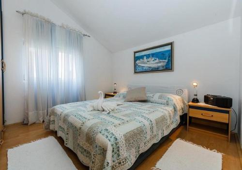 a bedroom with two beds and a large window at Apartments Roda in Supetar