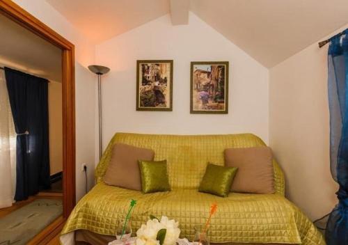 een slaapkamer met een geel bed met 3 kussens bij Apartments Roda in Supetar