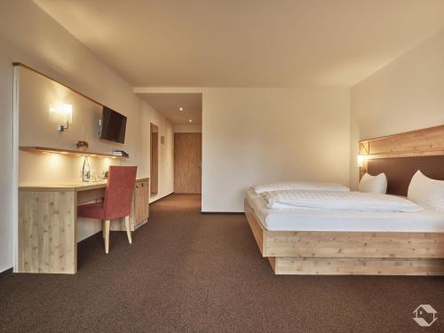 a hotel room with a bed and a desk at Landgasthof Adler Pelzmühle in Biederbach Baden-Württemberg