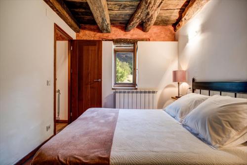 a bedroom with a large bed with a window at Casas Rurales Molinias in Fosado
