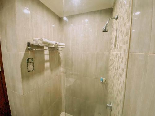 een douche met een glazen deur in de badkamer bij Sapphire Sky Hotel & Conference in Serpong
