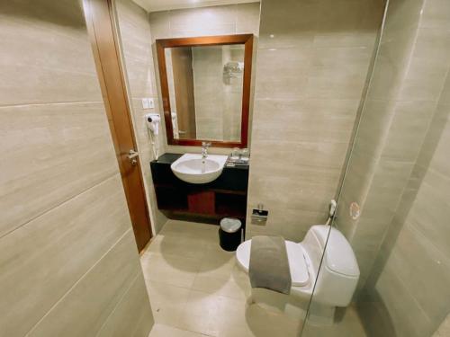 a small bathroom with a sink and a toilet at Sapphire Sky Hotel & Conference in Serpong