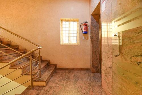 a staircase in a room with a fire extinguisher at FabHotel The BTM Palace - BTM Layout in Bengaluru