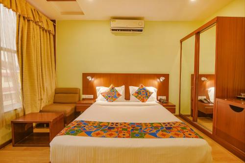 um quarto de hotel com uma cama e uma cadeira em FabHotel The BTM Palace em Bangalore