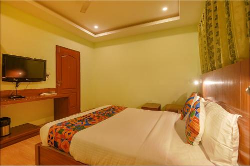 a hotel room with a bed and a television at FabHotel The BTM Palace - BTM Layout in Bengaluru