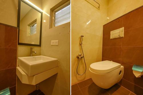 a bathroom with a toilet and a sink and a mirror at FabHotel The BTM Palace - BTM Layout in Bengaluru