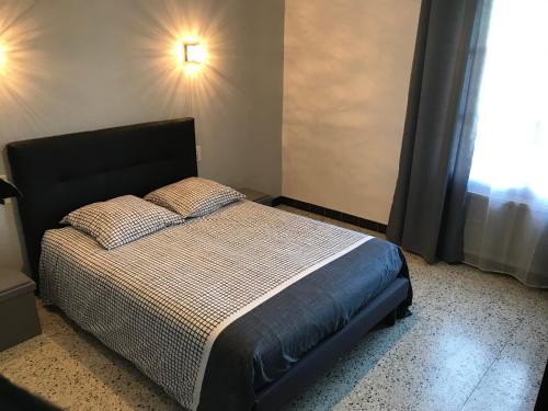 a bedroom with a bed and a window at APPARTEMENT TOUT CONFORT AVEC PARKING FERMÉ in Arles