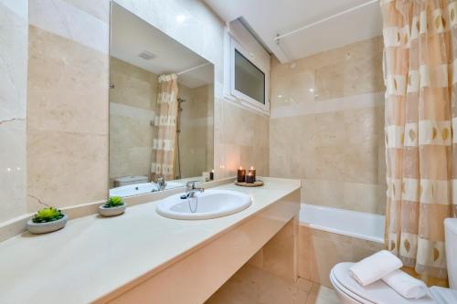 a bathroom with a sink and a toilet and a mirror at Villas Guzman - Apartamento Tramontana in Calpe