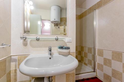 a bathroom with a sink and a mirror and a shower at Leonardo in Cagliari