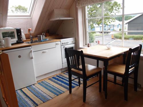 eine Küche mit einem Tisch, 2 Stühlen und einem Tisch sowie eine Küche mit in der Unterkunft Huggehus in Förslöv