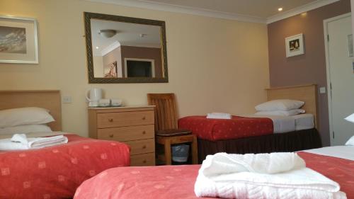 a hotel room with two beds and a mirror at Westholme Hotel in Blackpool