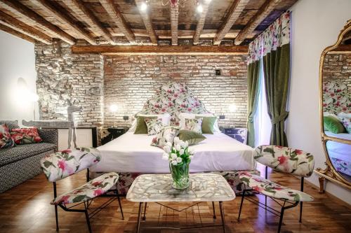 a bedroom with a bed and a brick wall at Vitrum - Como Luxury Suites in Como