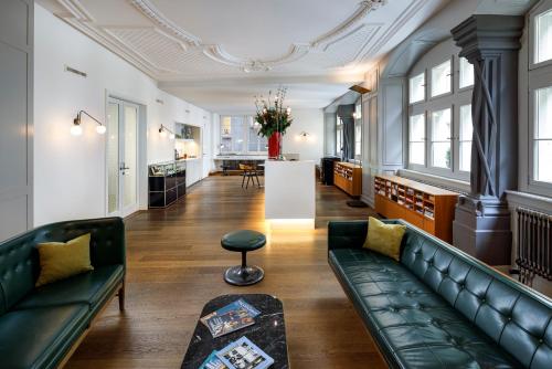 a living room filled with furniture and a large window at Marktgasse Hotel in Zurich