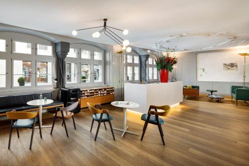 une chambre avec deux tables, des chaises et des fenêtres dans l'établissement Marktgasse Hotel, à Zurich