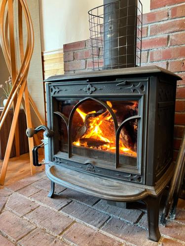 a wood stove in a room with a brick wall at Ocean View House in Atami