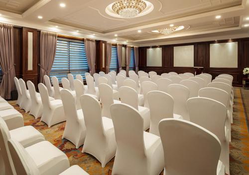 a conference room with white chairs and a chandelier at The Indus Valley in Leh