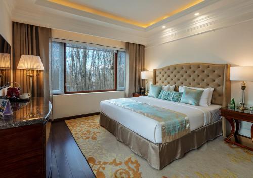 a large bedroom with a large bed and a desk at The Indus Valley in Leh