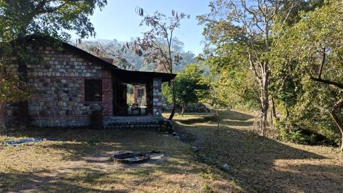 a small brick house in the middle of a forest at Wild Brook in Rishīkesh