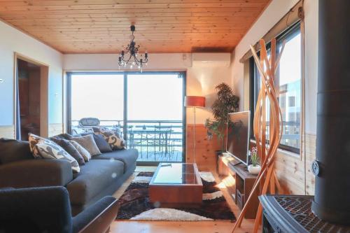 a living room with a couch and a large window at Ocean View House in Atami