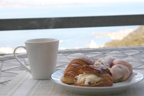 a plate of pastries on a table next to a cup at Ocean View House in Atami