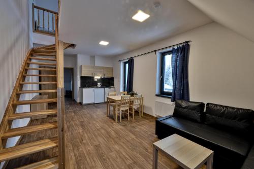 a living room with a staircase leading to a kitchen at Apartmány Na handě in Boží Dar