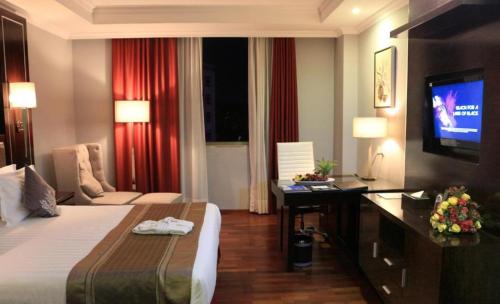 a hotel room with a bed and a television at Saro Maria Hotel in Addis Ababa
