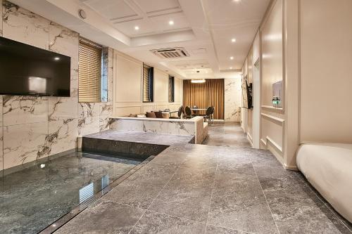 a hotel room with a large bathroom with a television at Hotel Wanted in Incheon