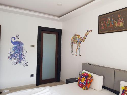 a bedroom with a bed and a giraffe on the wall at Athi Resorts in Bogmolo