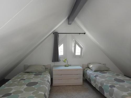 1 dormitorio con 2 camas, vestidor y ventana en Village de 19 gites avec Piscine et restaurant, Grand Vabre Nature en Conques