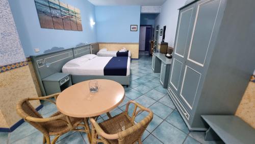 a small room with a table and a bed at Hotel Centro Congressi Polo Nautico in Salerno