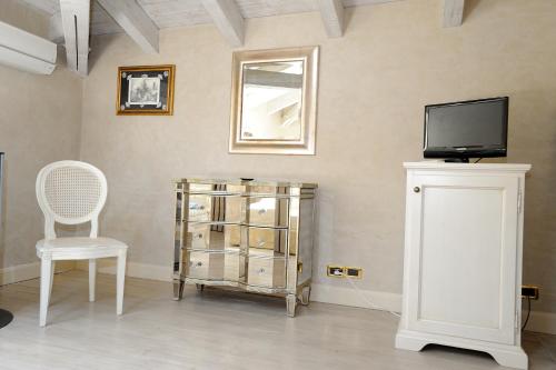 a room with a tv and a chair and a cabinet at Relais La Colombara Spa & Wellness in Travo