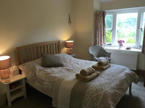 1 dormitorio con 1 cama con toallas en 200 year old Gardener's cottage, Mid Wales, en Llanidloes