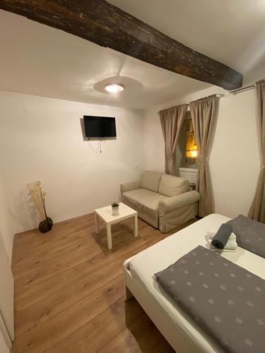 uma sala de estar com uma cama e um sofá em Rooms and apartments Nokturno em Zagreb