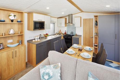 a kitchen and living room with a table in a caravan at Newquay Bay Resort in Newquay