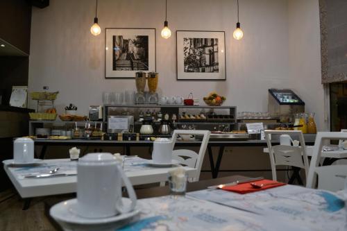 a restaurant with tables and white chairs and a counter at Hotel Continental in Angers