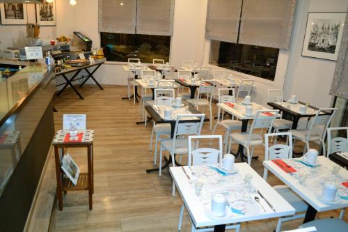 a dining room with tables and chairs in a restaurant at Hotel Continental in Angers