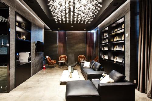 a lobby with leather couches and a table and chairs at Hotel Wanted in Incheon
