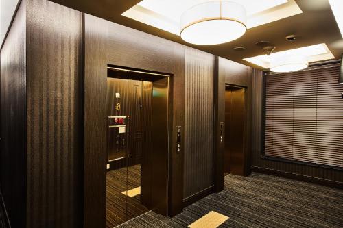 a hallway with wooden walls and a door with a light at Hotel Wanted in Incheon