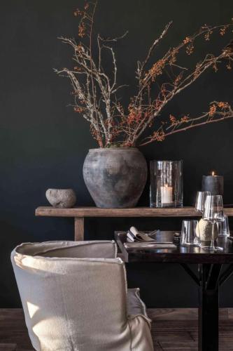 a table with a vase and a table with a chair at Wellness Hotel Volarik in Mikulov