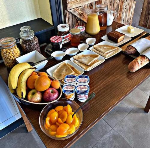 a table with a bunch of different types of food at Auberge du Raddon in Raddon-et-Chapendu