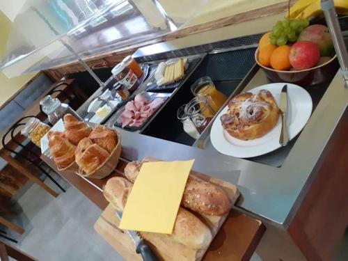 uma mesa de pequeno-almoço com pão, pastelaria e frutas em Auberge du Raddon em Raddon-et-Chapendu