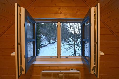 an open window in a cabin with a snow covered yard at Hotel Jirinka in Dolní Morava