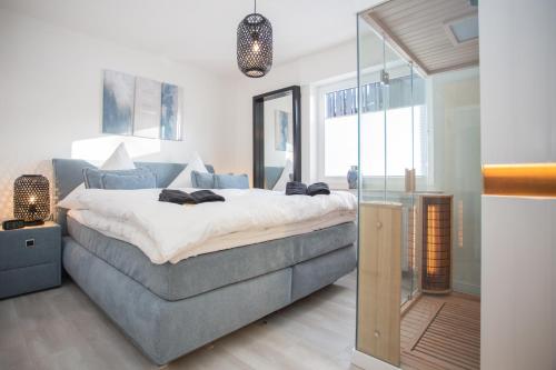 a bedroom with a large bed and a mirror at Astenperle II in Winterberg Infrarosauna, Massagesessel, Balkon in Winterberg