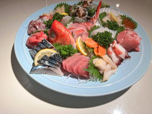 a plate of seafood and vegetables on a table at Ocean View House in Atami