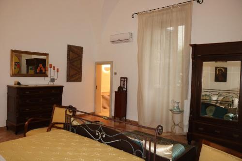 a bedroom with a bed and a dresser and a mirror at B&B Il Giardino di Paola in Alliste