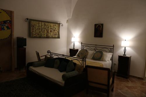 a bedroom with a bed and a couch and two lamps at B&B Il Giardino di Paola in Alliste