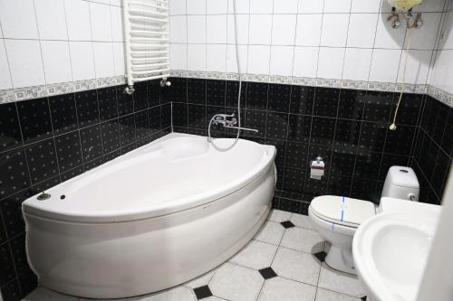 a bathroom with a tub and a toilet and a sink at Львівський in Lviv